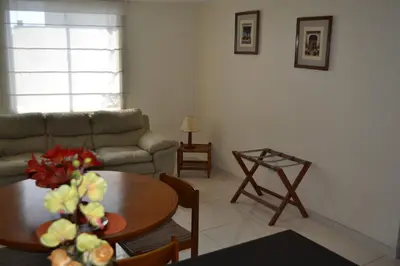 a living room with a table and a couch at Suite Service Apart Hotel in Lima
