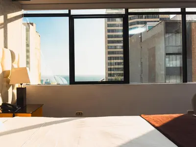 a bedroom with a bed and a large window at Hotel Ferré Miraflores in Lima