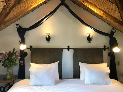 a bedroom with a bed with white pillows and lights at ARQUEOLOGO Exclusive Boutique Hotel Cusco - Centro Histórico in Cusco