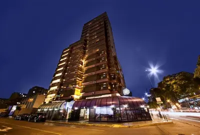 a tall building on a city street at night at J&A Classic Hotel in Lima