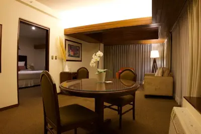 a hotel room with a table and a bedroom at J&A Classic Hotel in Lima