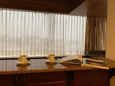 an open book sitting on a table with two cups at J&A Classic Hotel in Lima