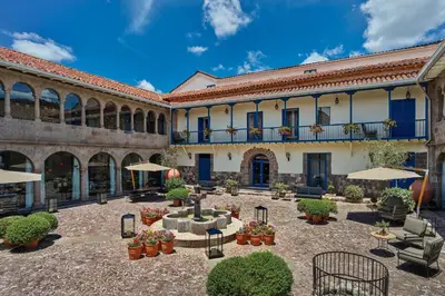 a courtyard in a building with tables and umbrellas at Palacio del Inka, a Luxury Collection Hotel, Cusco in Cusco