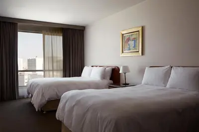 a hotel room with two beds and a window at LUOXO Hotel in Lima