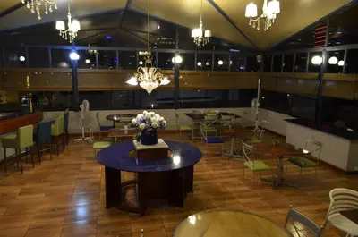a dining room with tables and chairs and a chandelier at Daniel's Apart Hotel in Lima