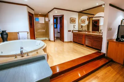 a large bathroom with a tub and a television at Daniel's Apart Hotel in Lima