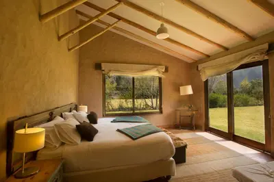 a bedroom with a large bed and a large window at Luxury House & Unique Experience at Sacred Valley, Urubamba, Cusco in Urubamba