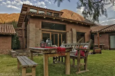 a picnic table and benches in front of a house at Luxury House & Unique Experience at Sacred Valley, Urubamba, Cusco in Urubamba