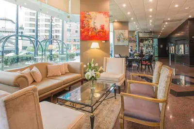 a lobby with a couch and chairs and a table at Delfines Hotel & Convention Center in Lima