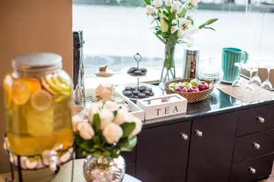 a buffet with flowers and a jar of tea on a counter at Delfines Hotel & Convention Center in Lima