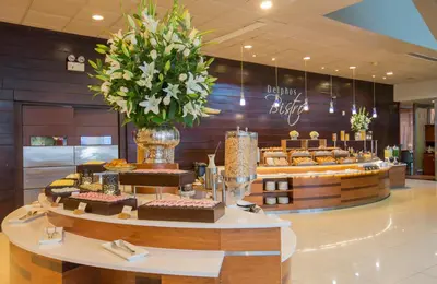 a bakery with cakes on a table in a lobby at Delfines Hotel & Convention Center in Lima