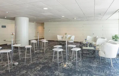 a room with white stools and tables and chairs at Delfines Hotel & Convention Center in Lima