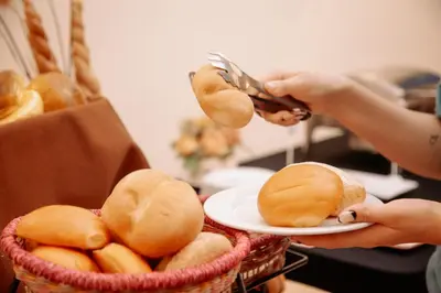 a person cutting a plate of bread with a pair of tongs at Hotel Carrera in Lima