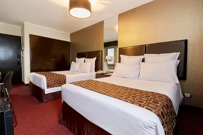 two beds in a hotel room with two beds at Hotel Carrera in Lima