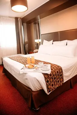 a hotel room with a large bed with two drinks on it at Hotel Carrera in Lima