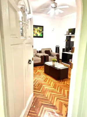 a living room with a white door and a couch at Departamento en San Isidro in Lima