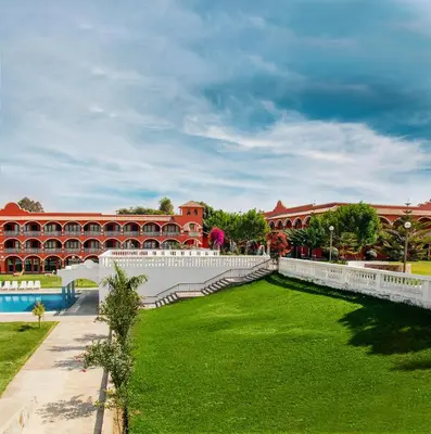 a large building with a green lawn in front of it at Hacienda San Juan Resort in Ica
