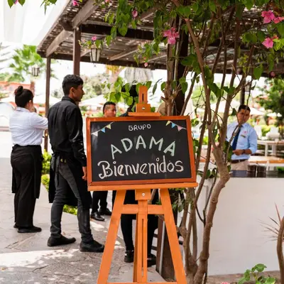 a sign for a restaurant with people standing around it at Hacienda San Juan Resort in Ica