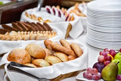 a table topped with baskets of bread and pastries and fruit at Hotel Gran Palma Huancayo in Huancayo
