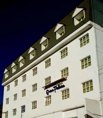 a large white building with a blue sign on it at Hotel Gran Palma Huancayo in Huancayo