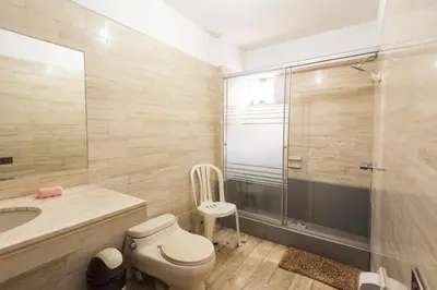 a bathroom with a toilet and a shower and a sink at Apartamento Edificio Pardo Cinco in Lima