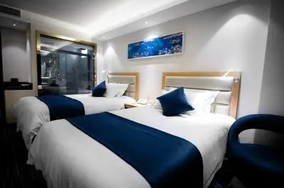 a hotel room with two beds with blue pillows at Lyz Business Hotel in Lima