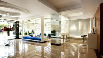 a living room with a blue couch in the middle at Lyz Business Hotel in Lima