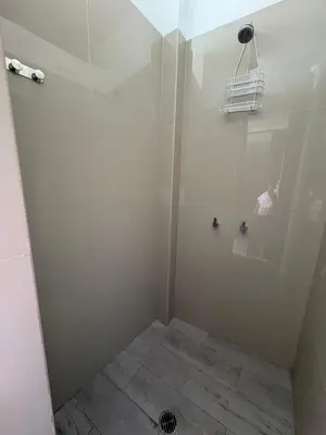 a small bathroom with a shower with a tile floor at La Casa de Bamboo in Ica