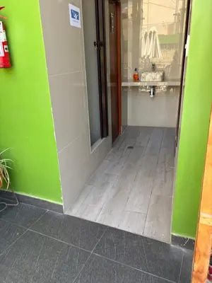 a hallway with a green wall and a door at La Casa de Bamboo in Ica