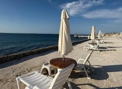 a table and chairs and an umbrella on a beach at ooo OCEAN VIEW APARTMENT PARACAS SOTAVENTO ooo in Paracas