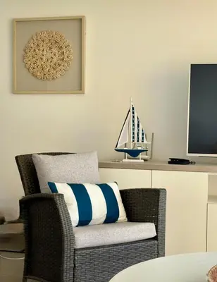 a wicker chair with a pillow and a tv at ooo OCEAN VIEW APARTMENT PARACAS SOTAVENTO ooo in Paracas
