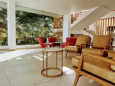 a living room with red chairs and a table at Hotel Balistra in Ica