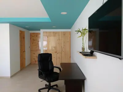 a room with a desk and a chair and a television at Hotel Balistra in Ica