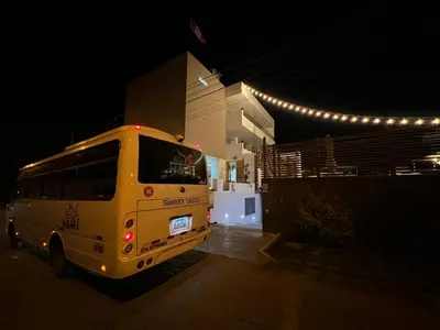 a yellow bus parked next to a building at night at Hotel Balistra in Ica
