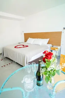a bedroom with a bed and a glass table with a bottle of champagne at Hotel Balistra in Ica