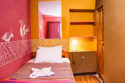 a small bedroom with a bed with two towels on it at Backpacker La Bo'M in Cusco