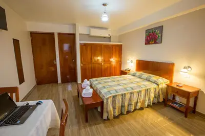a hotel room with a bed and a laptop on a table at Amazonia Siu Hostal in La Merced