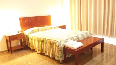 a hotel room with a bed with a table and a bed sidx sidx sidx at Amazonia Siu Hostal in La Merced
