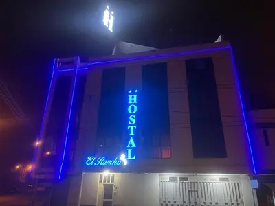 a building with a blue sign on it at night at Hostal El Rancho in Huancayo