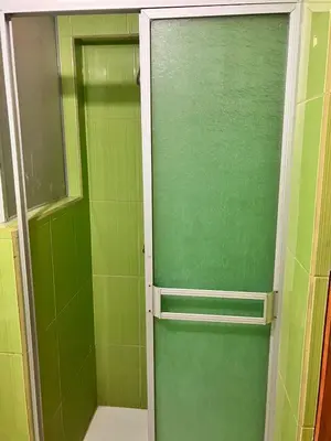 a green shower door in a green bathroom at Hostal El Rancho in Huancayo