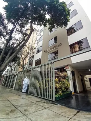 a man standing in front of a gate in front of a building at Hotel El Farolito in Lima