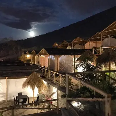 a group of tents at night with the moon in the sky at Ecocamp Huacachina in Ica