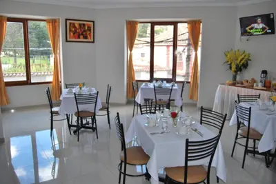 a dining room with white tables and chairs at Cusco House in Cusco