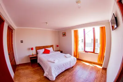 a bedroom with a bed and a large window at Cusco House in Cusco