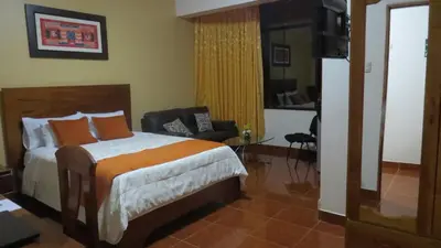 a bedroom with a bed and a chair in a room at Victtorios Hotel in Satipo