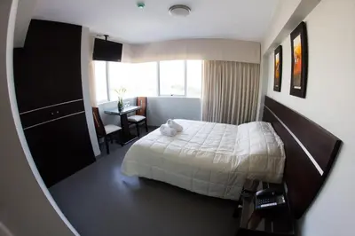 a hotel room with a bed and a window at Mariategui Hotel & Suites in Lima