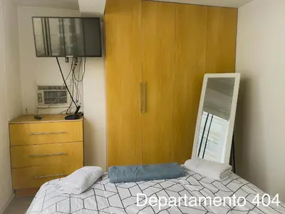 a bedroom with a bed and a dresser with a mirror at Departamento Monterrico in Lima