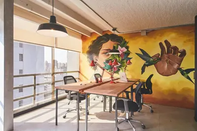 a mural in an office with a table and chairs at Naia Hoteles in Lima