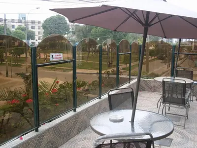 a table and chairs with an umbrella on a patio at CasaHotel Jockey Plaza Mall in Lima