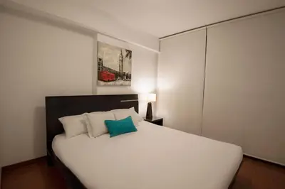 a bedroom with a large white bed with a blue pillow at Mariel Hotel Boutique in Lima